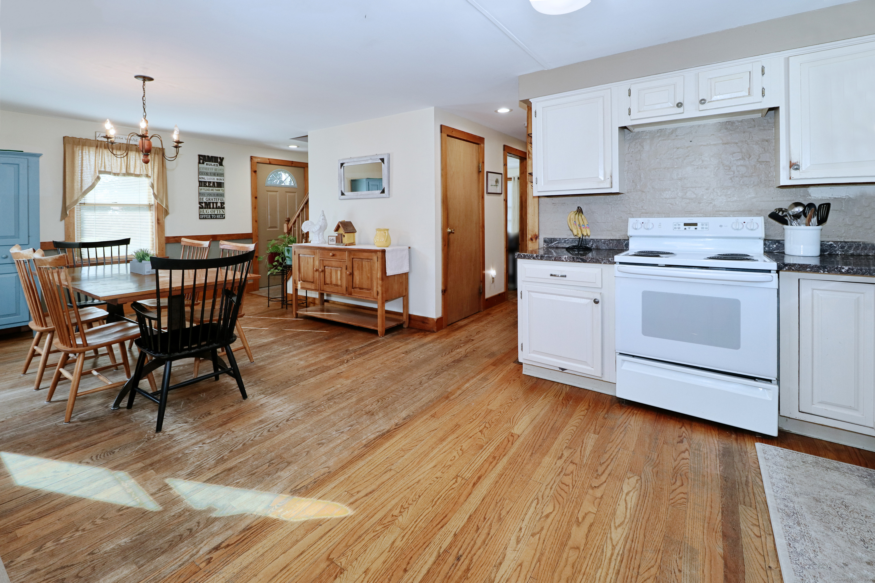 28 Stillson Place Fairfield, CT 06824 - Photo 12 of 28 a kitchen with stainless steel appliances granite countertop a stove top oven a refrigerator a dining table and chairs with wooden floor