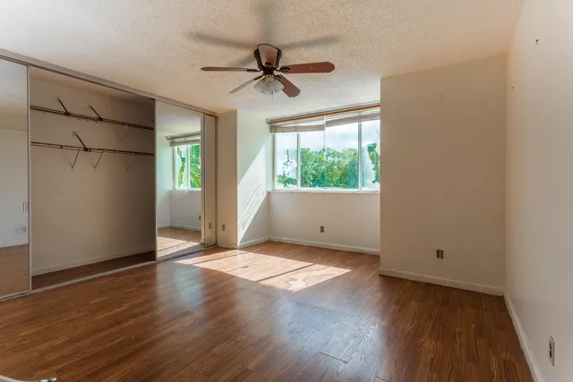 a view of a livingroom with wooden floor and a ceiling fan