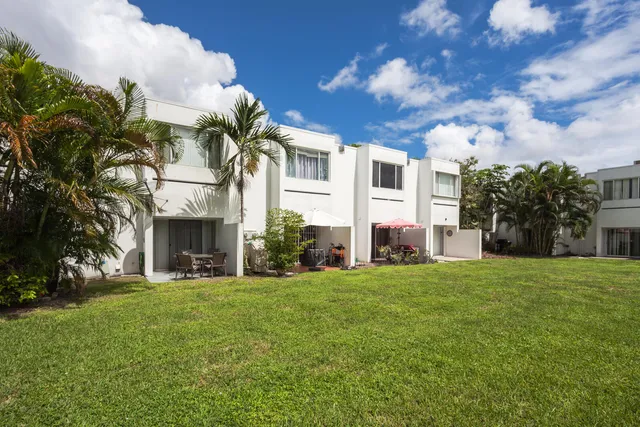 a front view of a house with a garden and trees