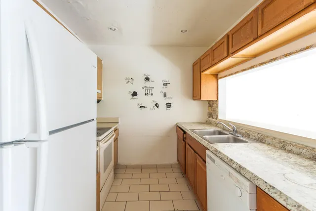 a kitchen with granite countertop a sink and a refrigerator