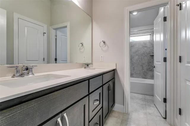 a bathroom with a double vanity sink a tub and a mirror