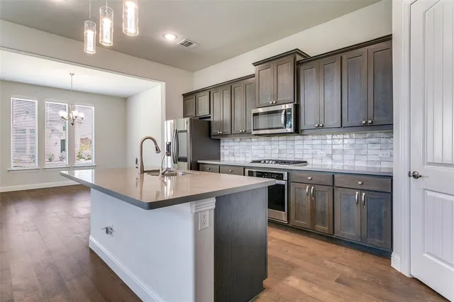 a kitchen with stainless steel appliances granite countertop a sink stove and cabinets