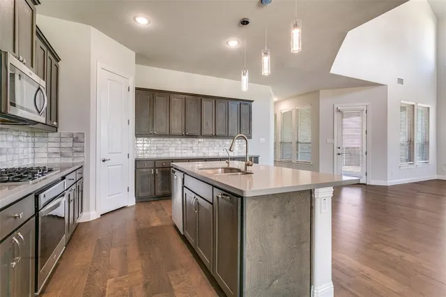 a kitchen with granite countertop a sink stove and cabinets