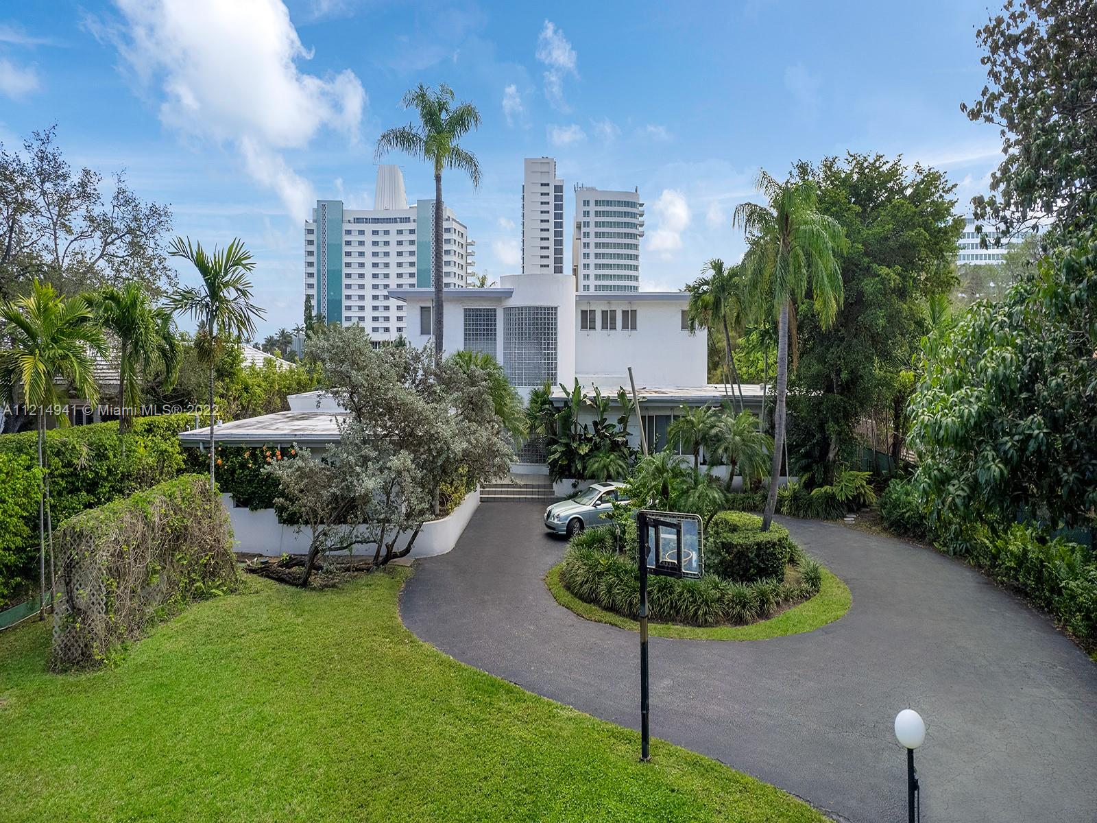 4525 Pine Tree Drive Miami Beach, FL 33140 - Photo 16 of 19 a view of a garden with plants and large trees