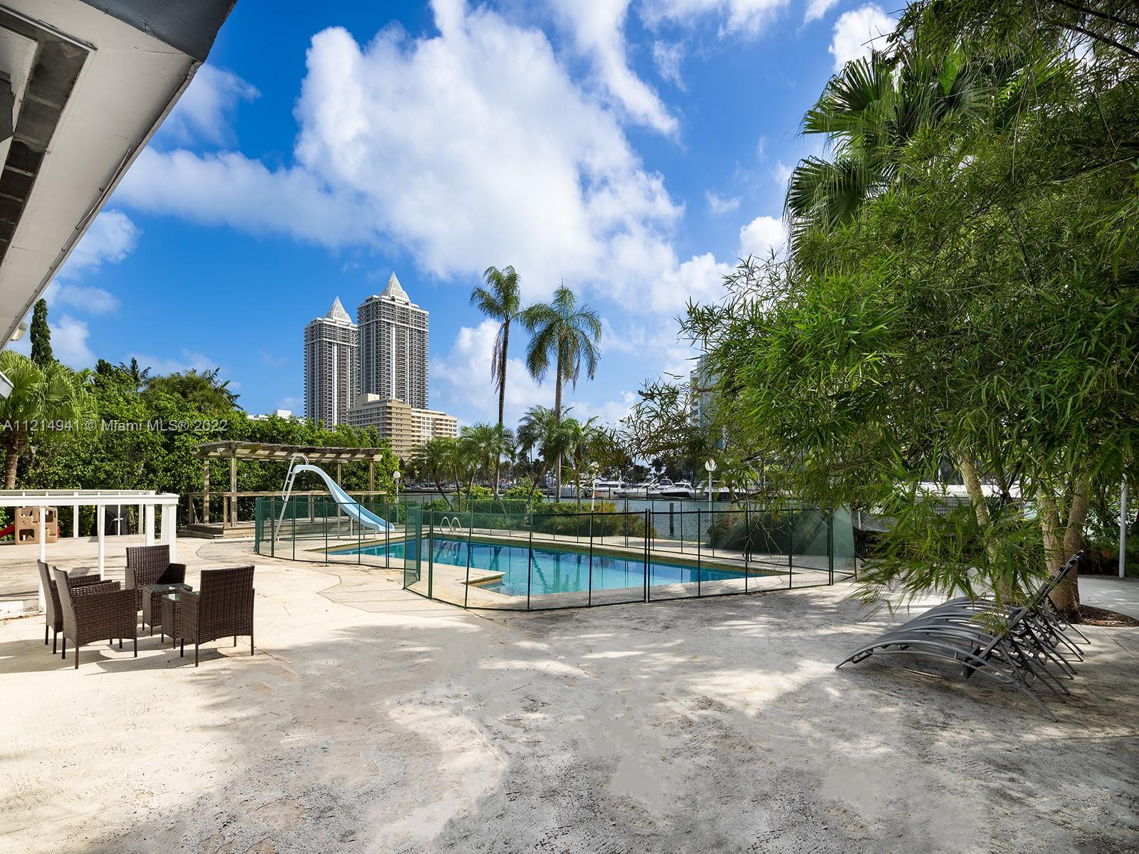 4525 Pine Tree Drive Miami Beach, FL 33140 - Photo 17 of 19 a view of a chair and tables in the patio