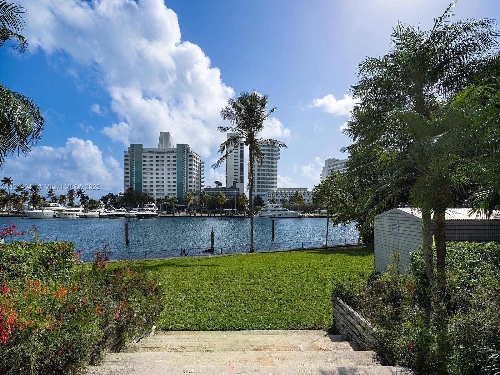 4525 Pine Tree Drive Miami Beach, FL 33140 - Photo 18 of 19 a view of a house with a swimming pool and a garden