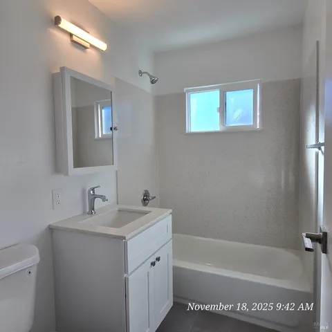 a bathroom with a tub a sink and mirror