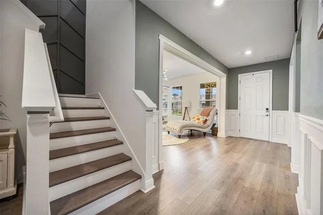 a kitchen with stainless steel appliances kitchen island granite countertop a refrigerator a stove a sink dishwasher and a dining table with wooden floor