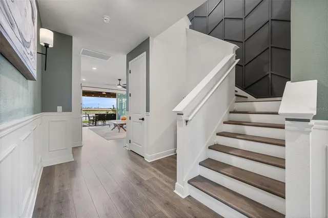 a kitchen with stainless steel appliances kitchen island granite countertop a wooden floor and white cabinets