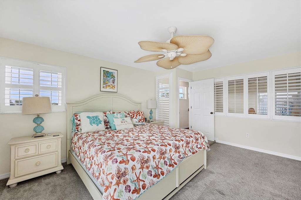 3547 Gasparilla Road Boca Grande, FL 33921 - Photo 26 of 43 a bedroom with a large bed and a chandelier
