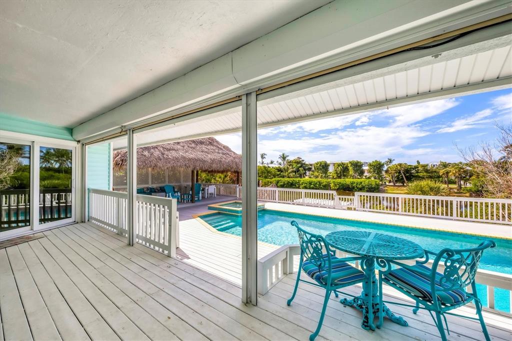 3547 Gasparilla Road Boca Grande, FL 33921 - Photo 30 of 43 a view of a porch with furniture and wooden floor
