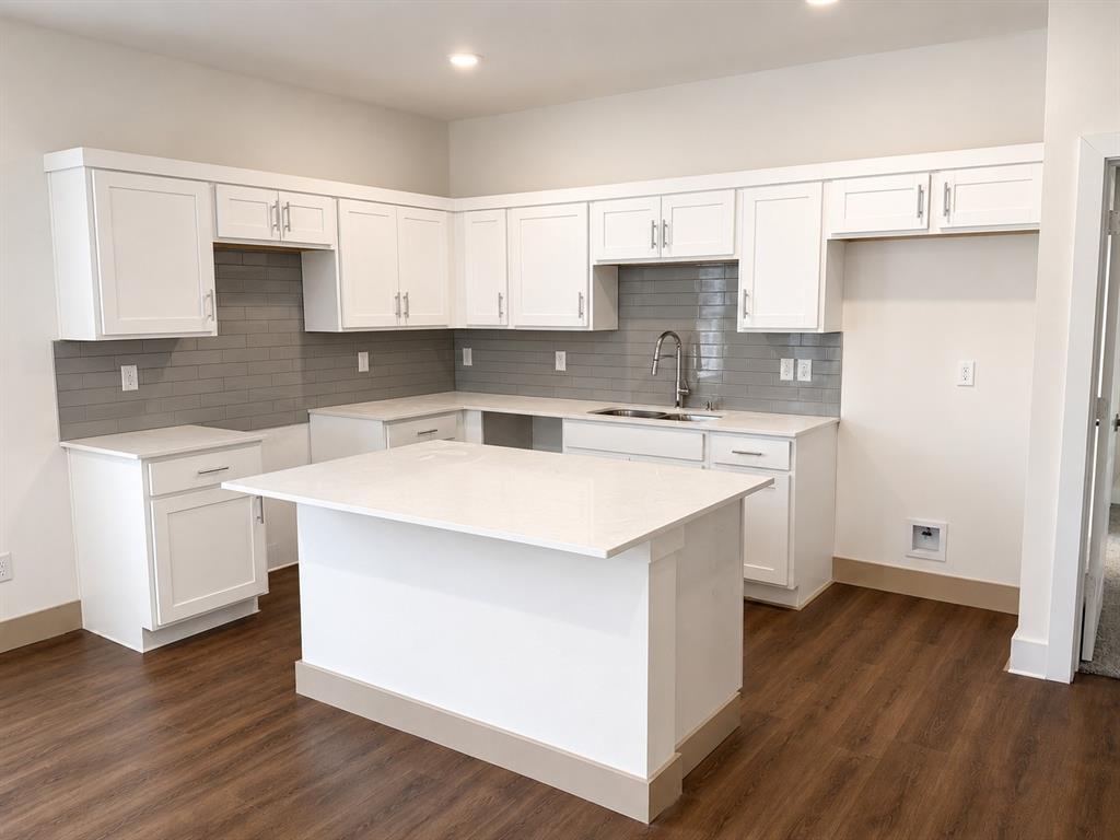 3529 Cleveland Street Dallas, TX 75215 - Photo 2 of 5 a kitchen with a sink a stove a refrigerator and white cabinets