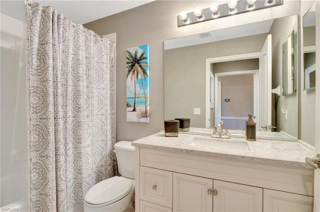8600 Cedar Hammock Circle, Unit 1313 Naples, FL 34112 - Photo 25 of 41 a bathroom with a sink a toilet and shower curtain