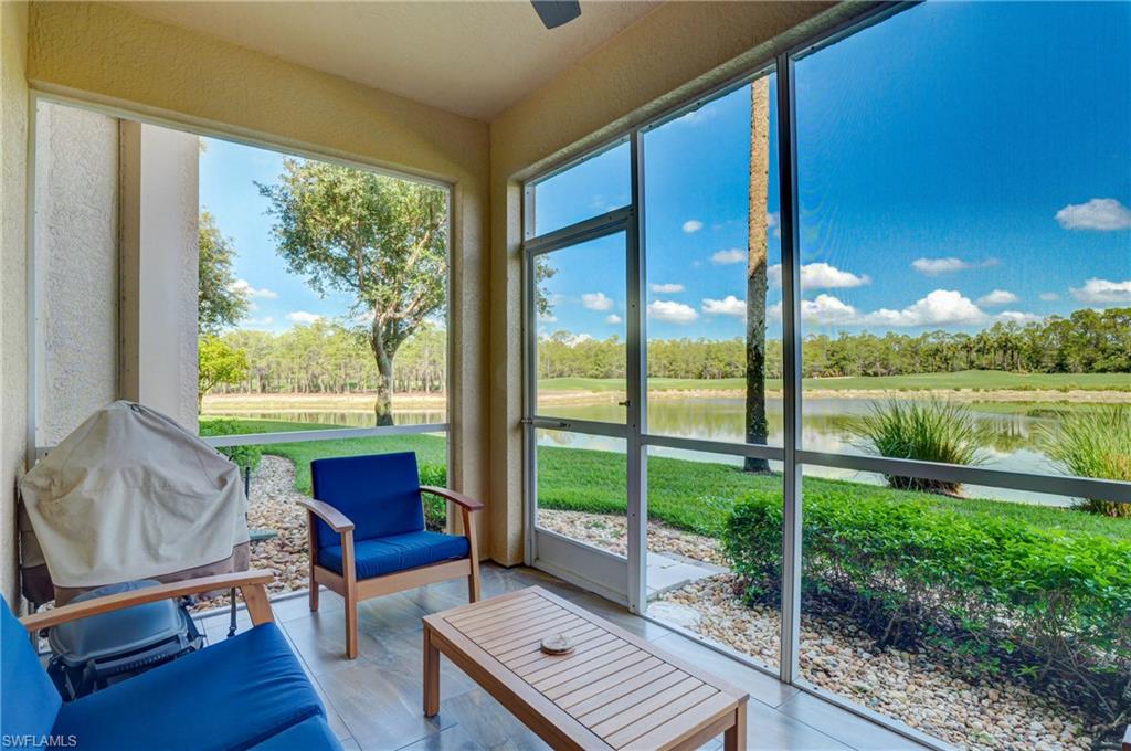 8600 Cedar Hammock Circle, Unit 1313 Naples, FL 34112 - Photo 28 of 41 a living room with couch and a floor to ceiling window