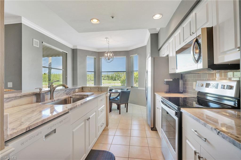 8600 Cedar Hammock Circle, Unit 1313 Naples, FL 34112 - Photo 9 of 41 a kitchen with stainless steel appliances granite countertop a sink stove and cabinets