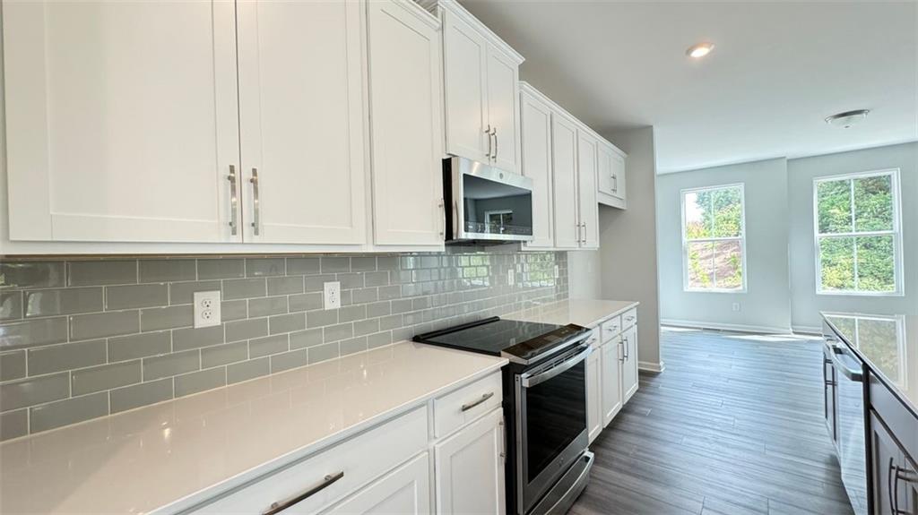 1479 Creekside Circle Northwest Atlanta, GA 30318 - Photo 11 of 42 a kitchen with stainless steel appliances a sink dishwasher stove microwave and cabinets with wooden floor