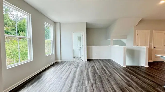 a view of a room with wooden floor and windows