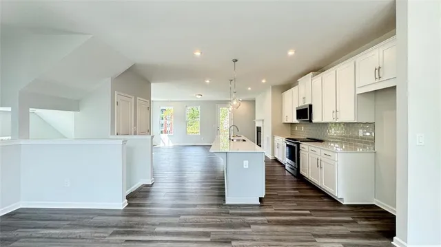 a large kitchen with stainless steel appliances granite countertop a stove and a refrigerator
