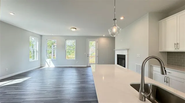a view of an empty room with window and wooden floor