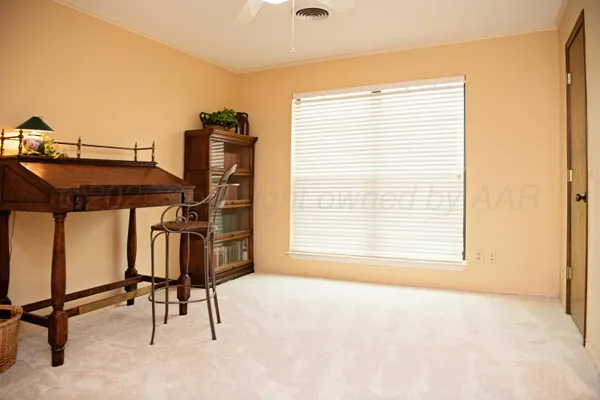 a view of a workspace with furniture and a window