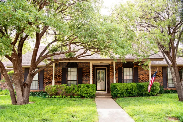 front view of a brick house with a yard