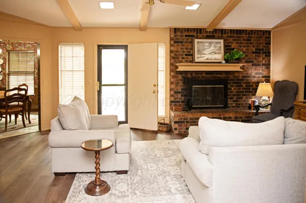 a living room with furniture a fireplace and wooden floor