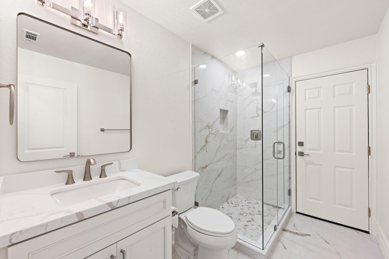 9337 Crocker Road Granite Bay, CA 95746 - Photo 17 of 56 a bathroom with a granite countertop sink toilet a mirror a vanity and shower