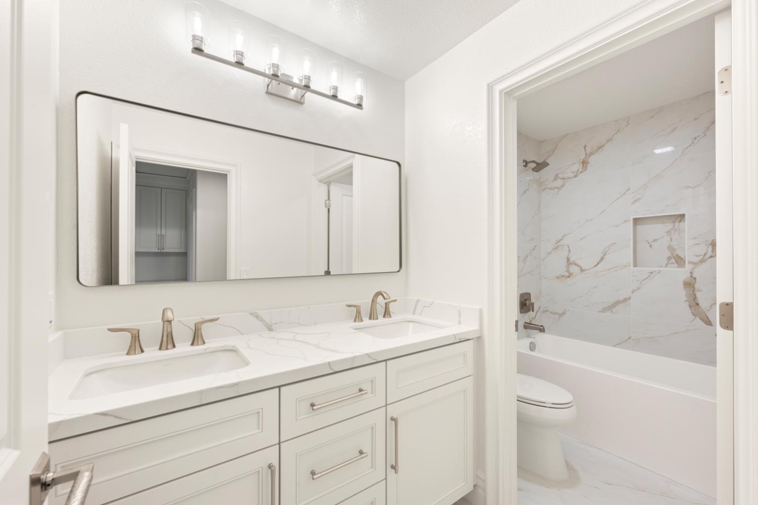 9337 Crocker Road Granite Bay, CA 95746 - Photo 31 of 56 a bathroom with a sink a toilet and a large mirror