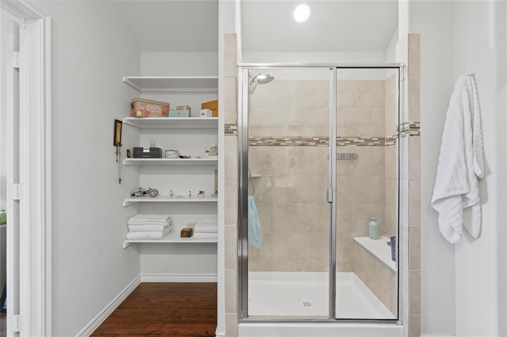 10101 Travis Road Little Elm, TX 75068 - Photo 23 of 26 a bathroom with a glass shower door