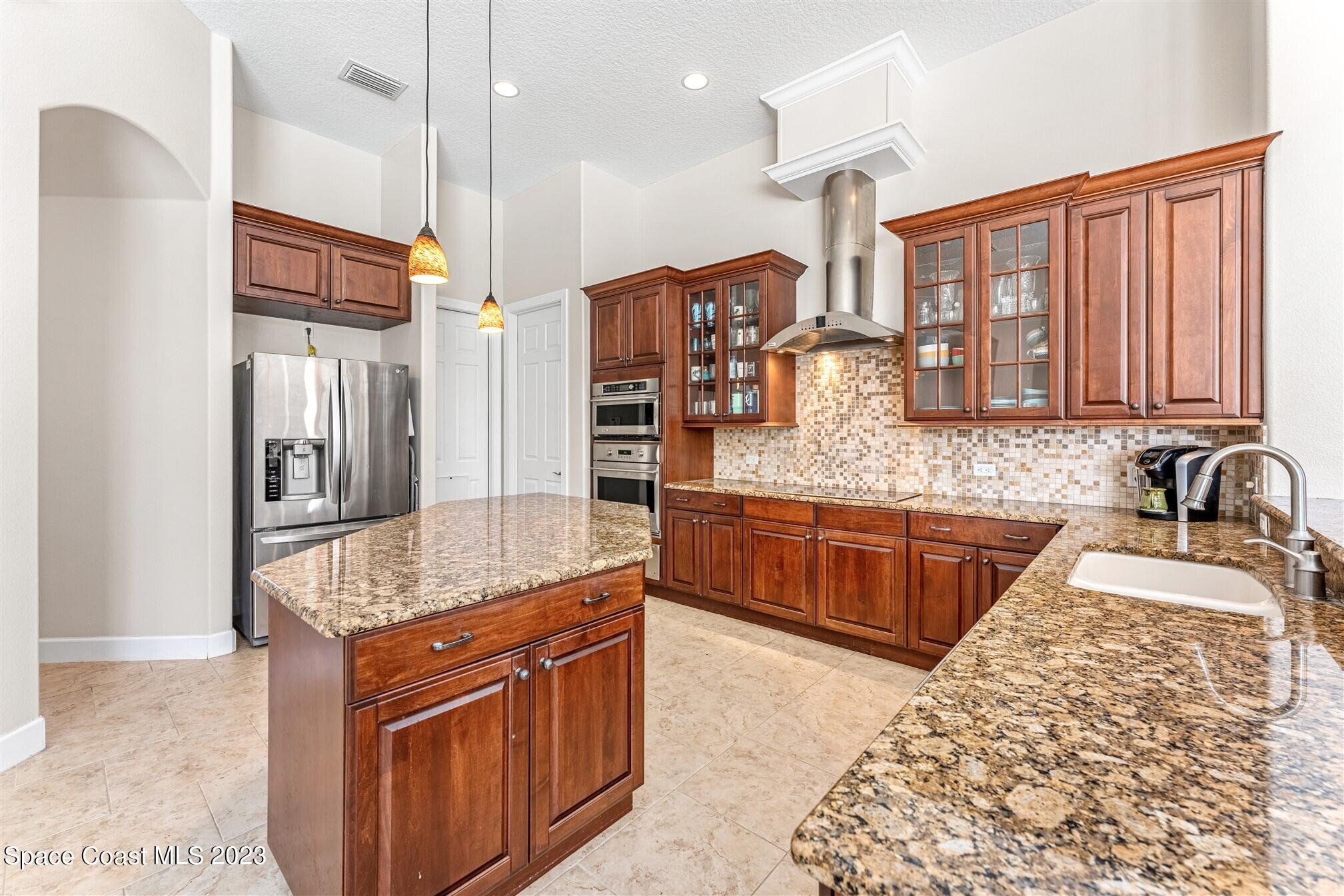 3550 Thurloe Drive Rockledge, FL 32955 - Photo 11 of 44 a kitchen with stainless steel appliances granite countertop a sink stove and refrigerator