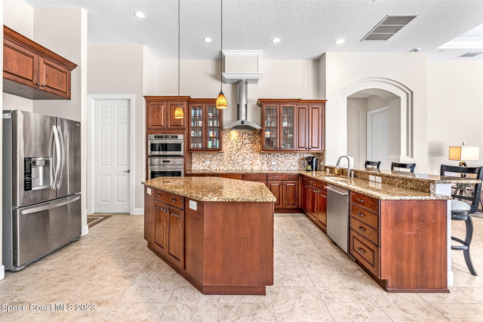 3550 Thurloe Drive Rockledge, FL 32955 - Photo 12 of 44 a large kitchen with stainless steel appliances granite countertop a stove a sink and a refrigerator