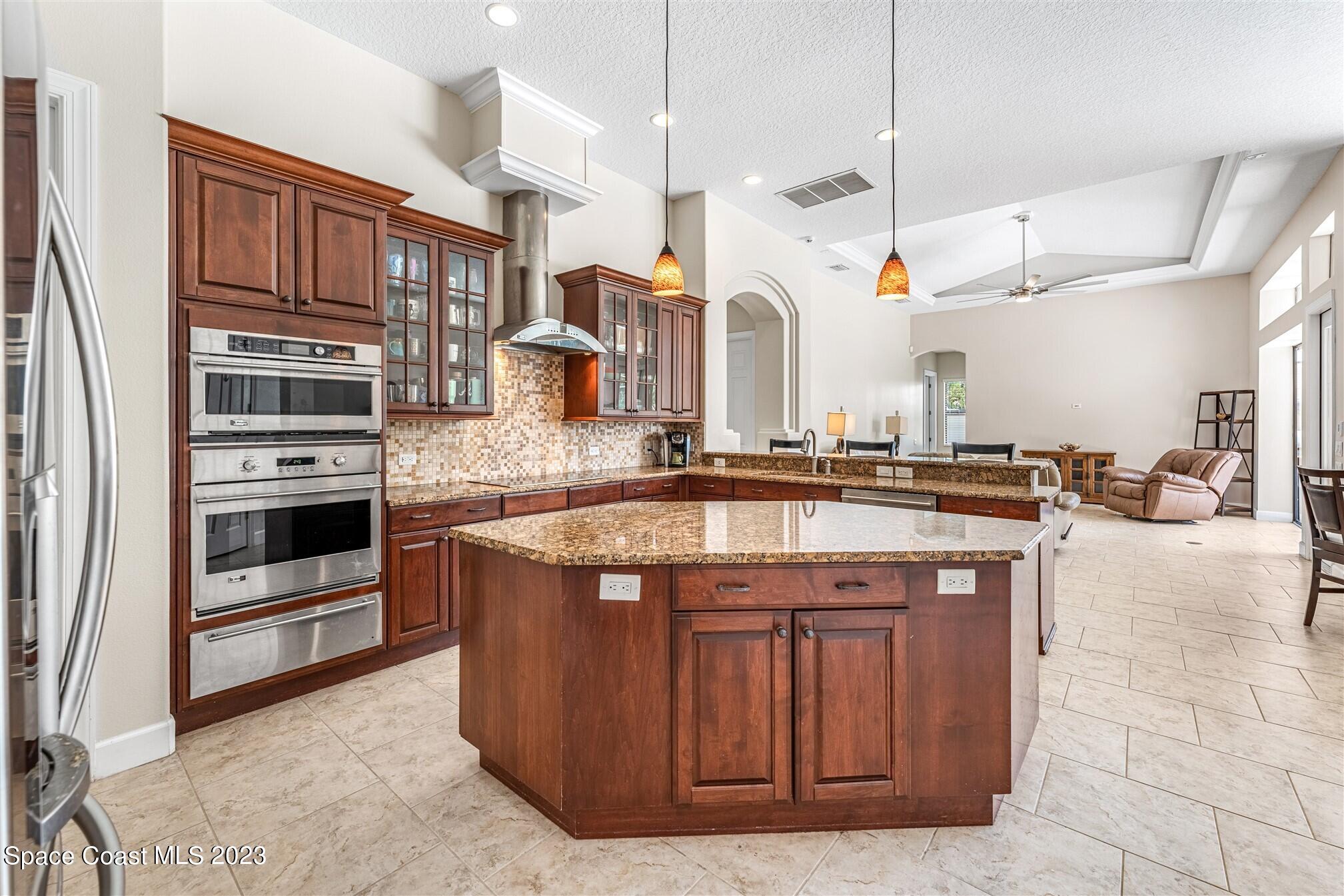 3550 Thurloe Drive Rockledge, FL 32955 - Photo 14 of 44 a kitchen with stainless steel appliances granite countertop a stove a sink and a refrigerator