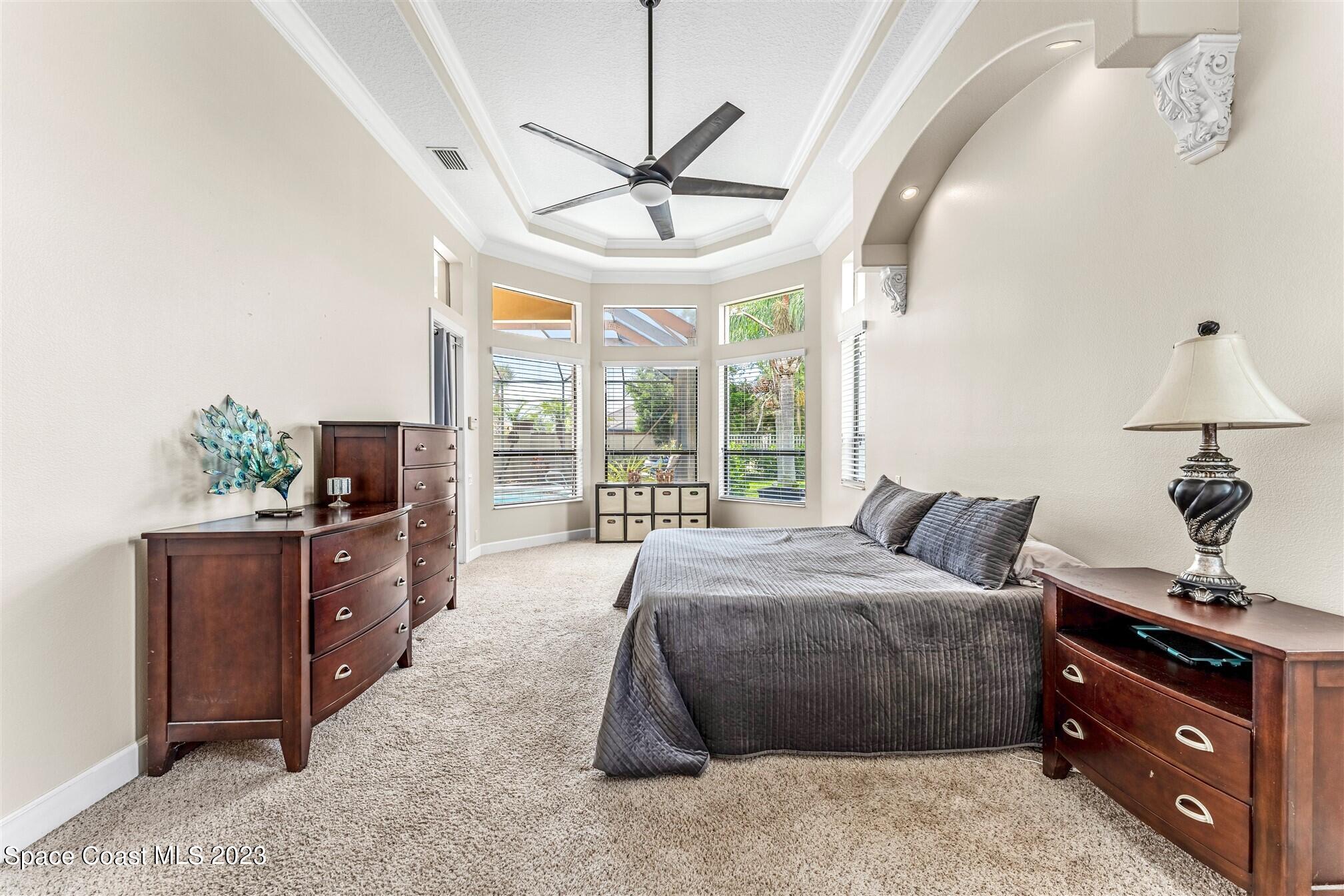 3550 Thurloe Drive Rockledge, FL 32955 - Photo 22 of 44 a spacious bedroom with a bed and a chandelier