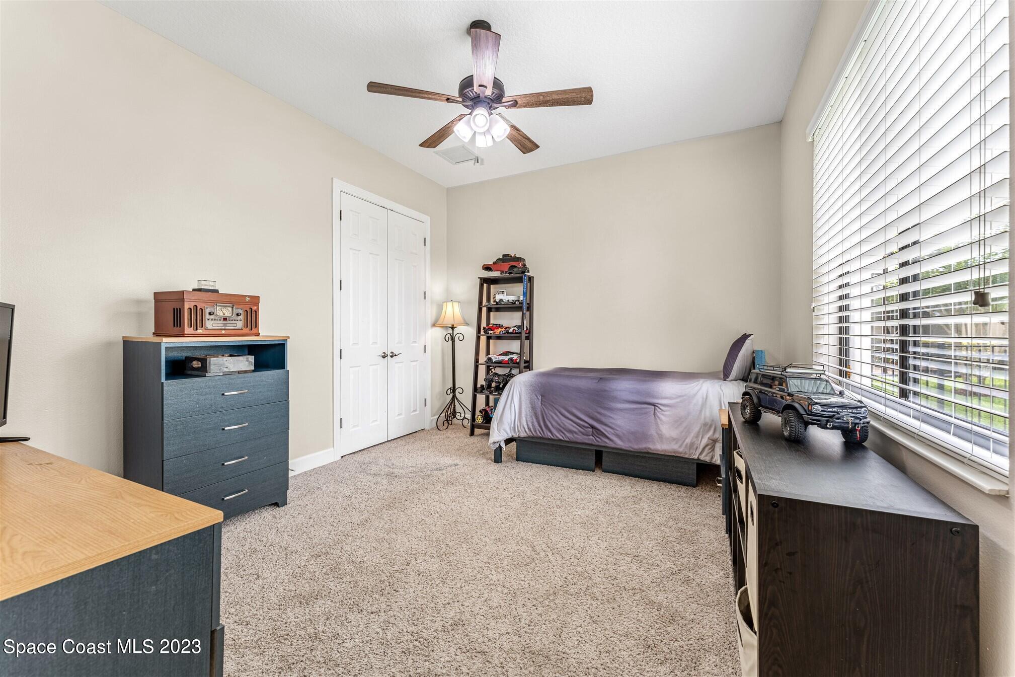 3550 Thurloe Drive Rockledge, FL 32955 - Photo 29 of 44 a bedroom with a bed and a chandelier