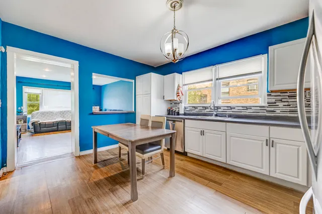 a kitchen with stainless steel appliances granite countertop a sink dishwasher stove with wooden floor and cabinets