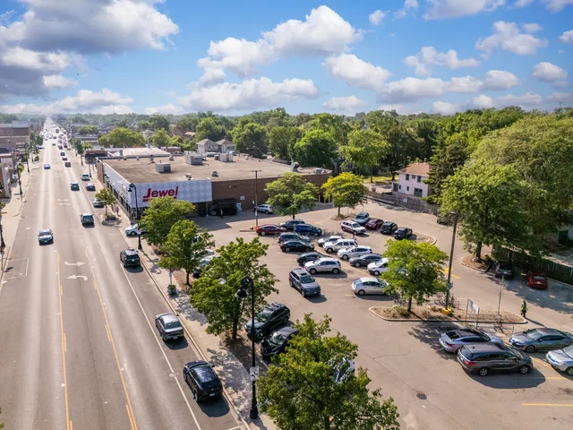 an aerial view of a house with swimming pool and large trees