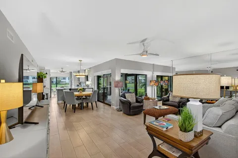 a living room with furniture kitchen view and a large window