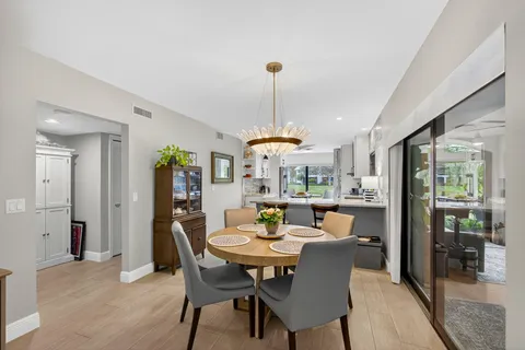 a dining room with furniture wooden floor and a chandelier