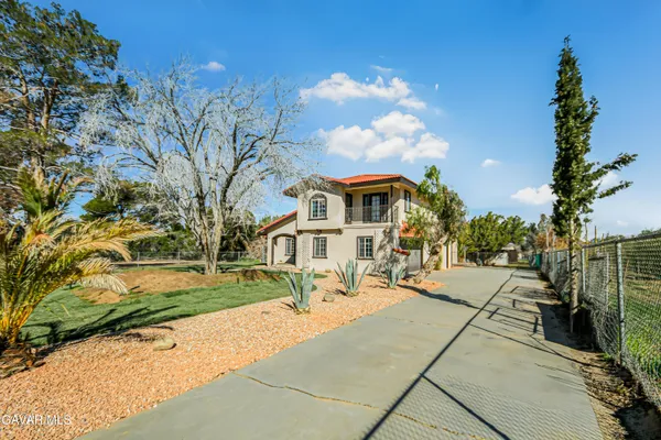 a front view of a house with a yard and potted plants