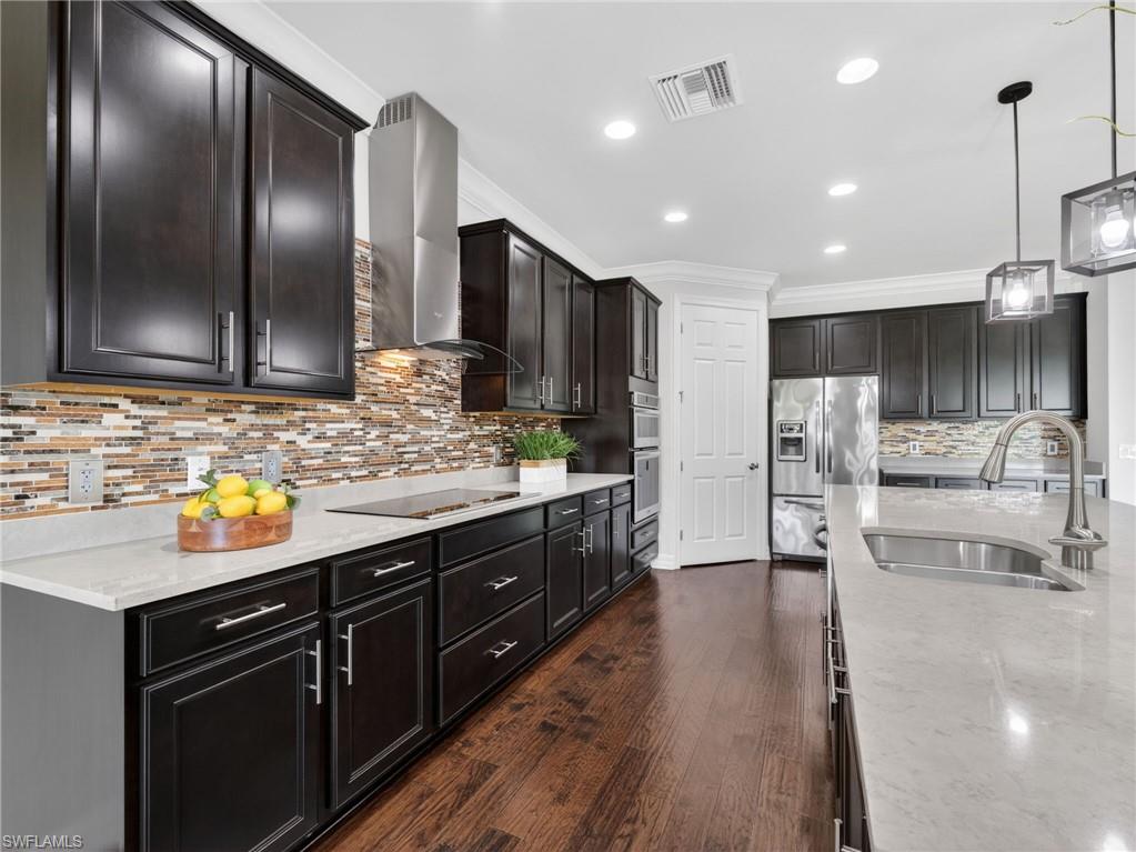 6124 Victory Drive Ave Maria, FL 34142 - Photo 7 of 50 a kitchen with stainless steel appliances kitchen island granite countertop a sink and cabinets