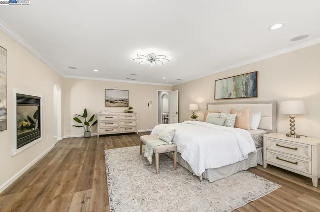 a spacious bedroom with a bed and a flat screen tv