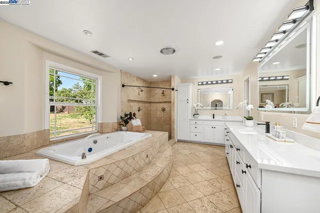 a bathroom with a tub sink and mirror