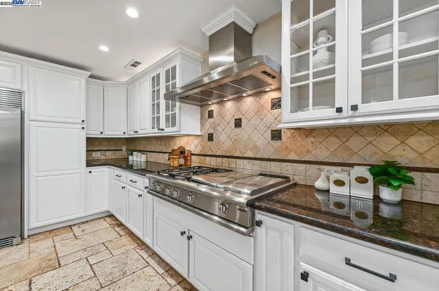 a kitchen with stainless steel appliances granite countertop a sink a stove and a granite counter tops
