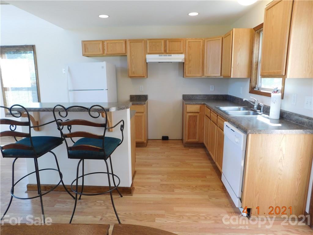 5612 Stack Road Monroe, NC 28112 - Photo 6 of 14 a kitchen with granite countertop a stove a sink and a dining table with wooden cabinet