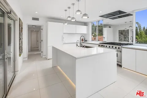 a kitchen with a sink a stove a refrigerator and cabinets