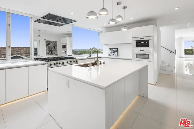a kitchen with a sink a stove and chairs