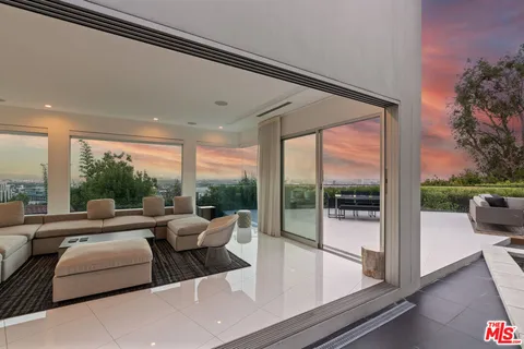 a living room with furniture and a floor to ceiling window