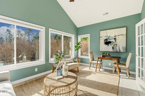 a view of a dining room and livingroom with furniture wooden floor a chandelier