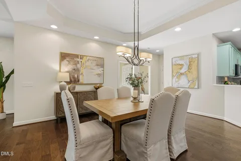 a kitchen with a refrigerator a stove a sink dishwasher a oven with a dining table and chairs