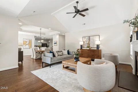 a living room with furniture a fireplace and a chandelier